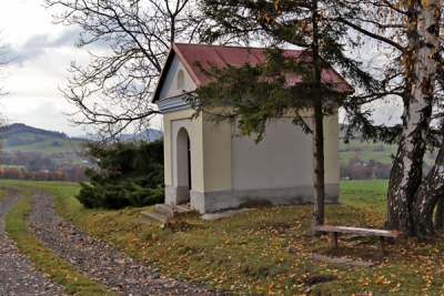 Zděn&aacute; kaplička v poli pod lesem